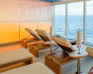A contemporary spa and wellness room aboard a cruise ship featuring wooden lounge chairs
