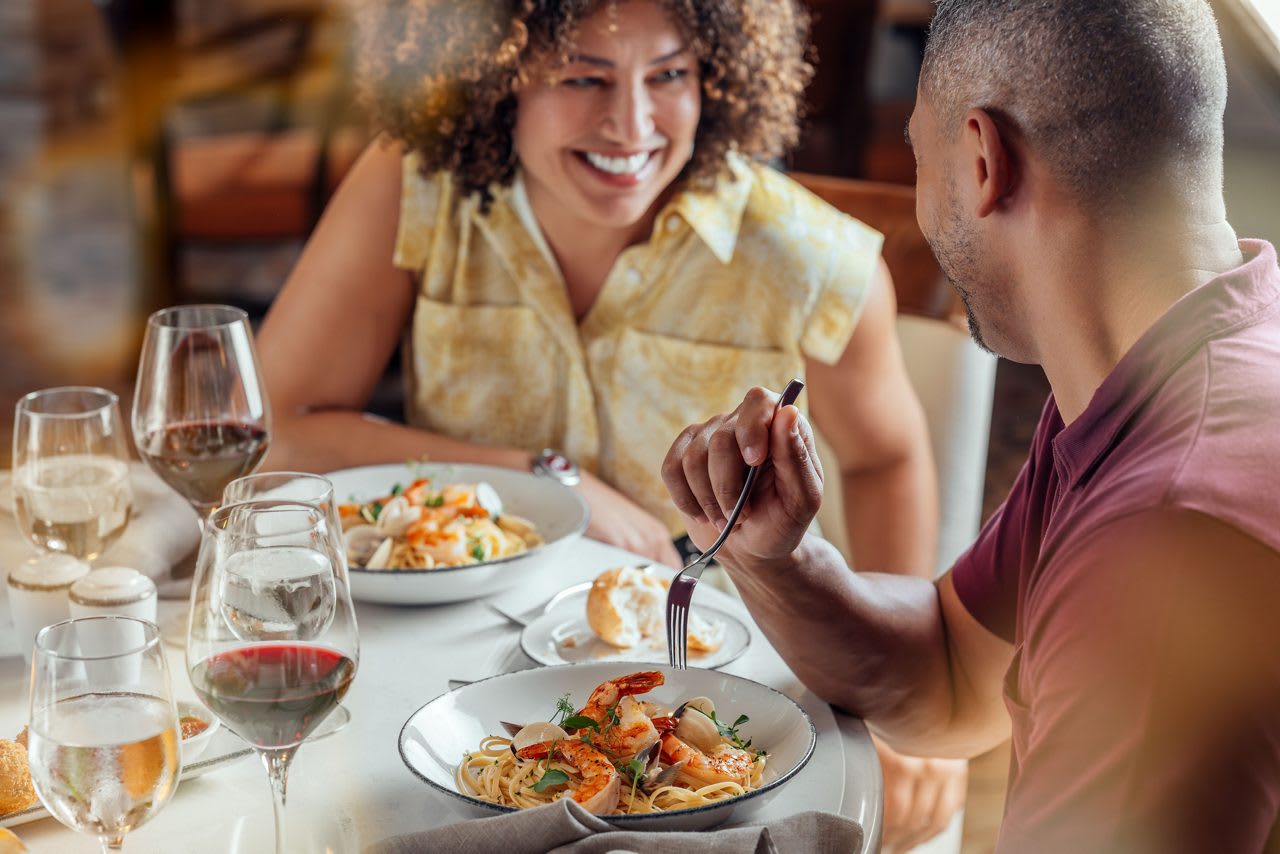 A couple enjoys an elegant dinner at Sabatini restaurant, sharing fine Italian cuisine with wine