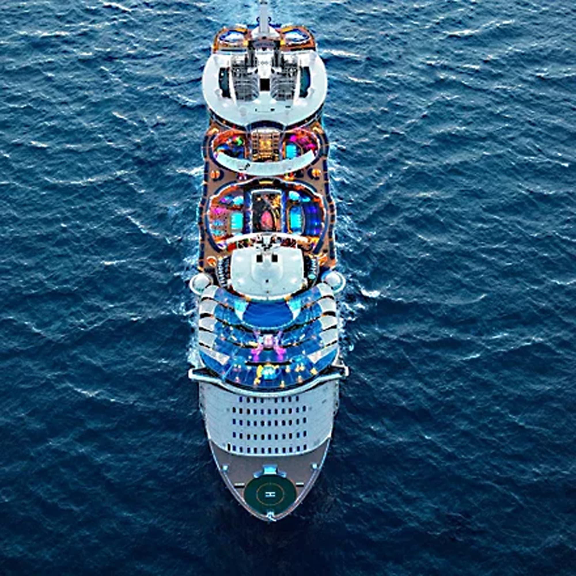 An overhead aerial photograph of a large modern cruise ship showcasing multiple colorful deck areas