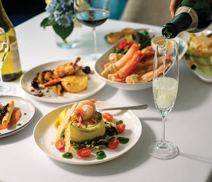 An elegant dining scene showcasing a multi-course plated meal with fresh seafood, vegetables