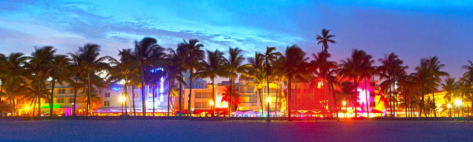 A vibrant twilight view of Miami Beach's iconic Art Deco Historic District, featuring colorful