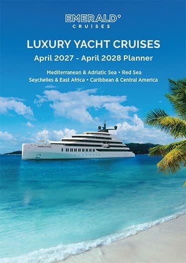 A luxurious Emerald Cruises yacht anchored in pristine turquoise waters off a tropical island beach