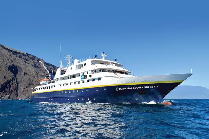 The National Geographic Gemini, a modern expedition cruise ship, anchors in crystalline blue waters
