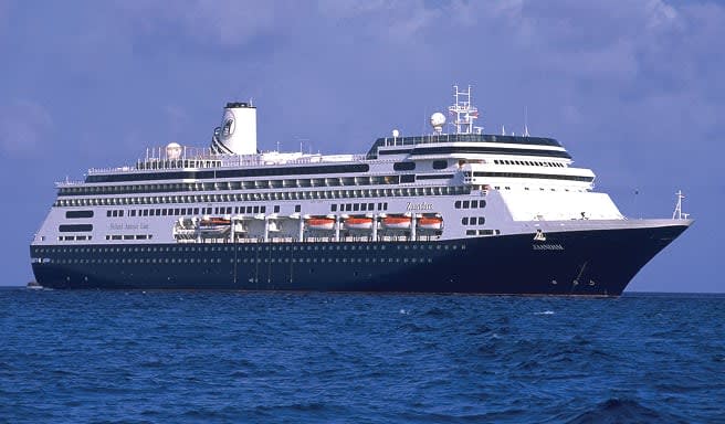 A sleek, modern cruise ship with a dark blue and white color scheme sailing on blue ocean waters