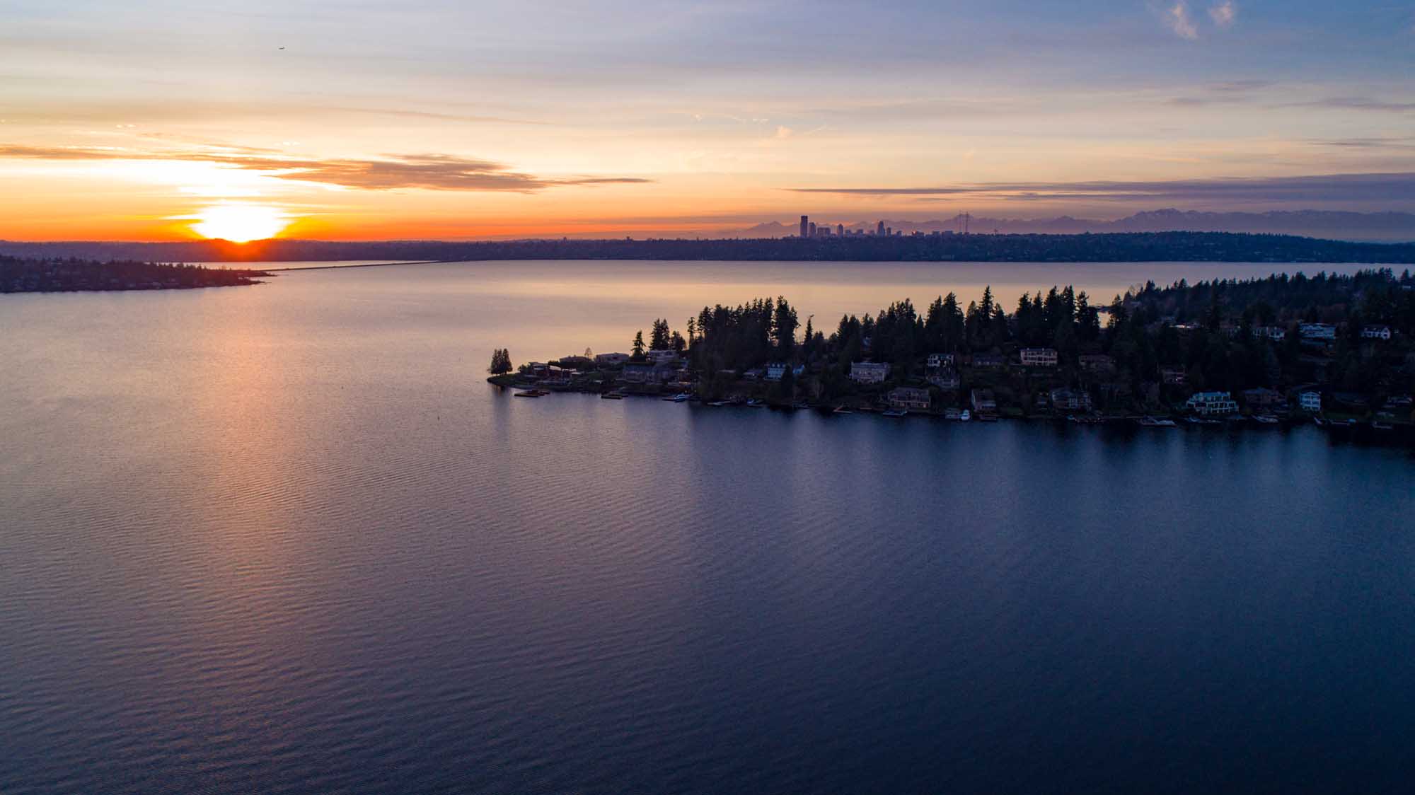 A breathtaking sunset view over Lake Washington, featuring a residential waterfront community