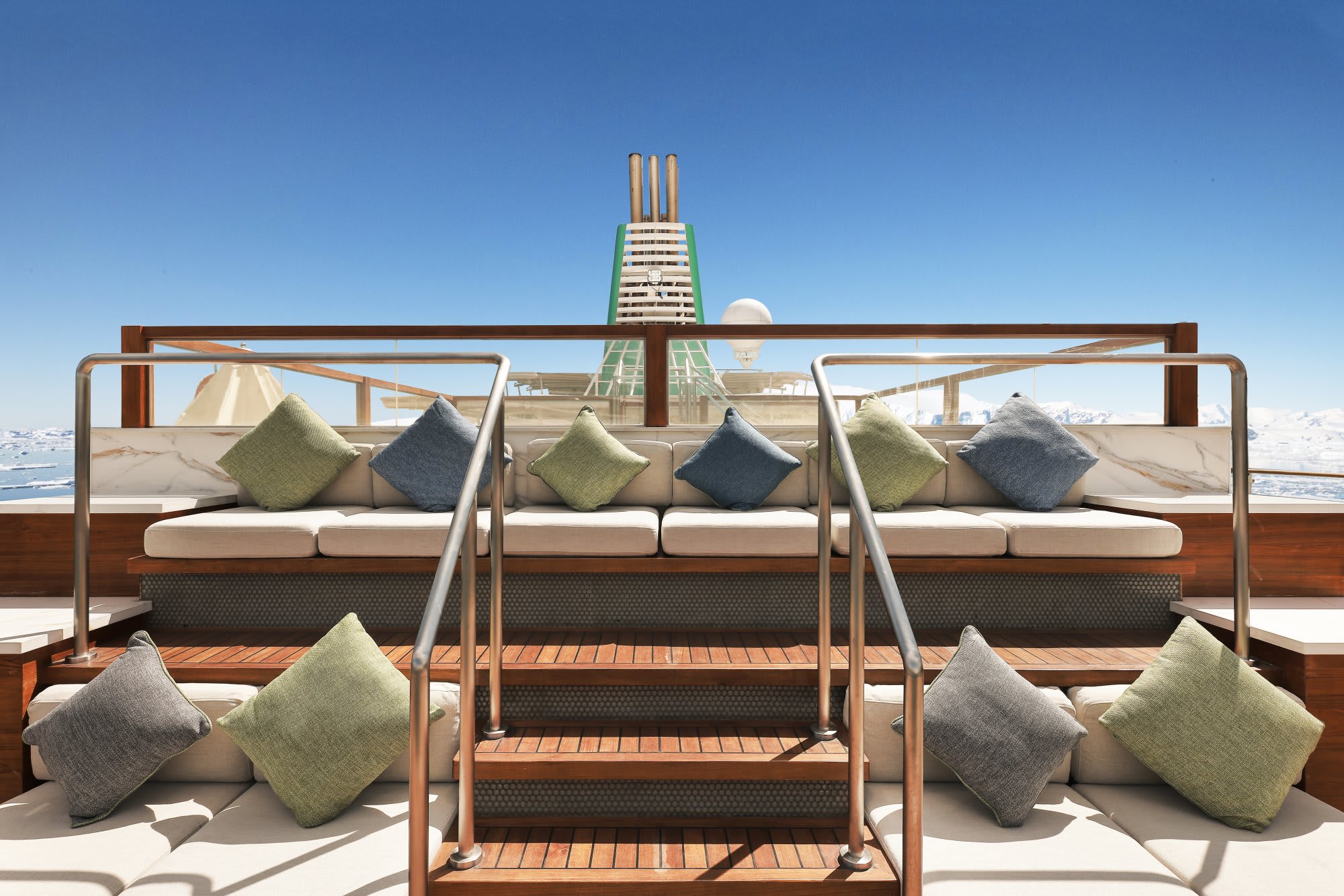 A luxurious sun deck aboard an expedition cruise ship featuring multiple lounge areas with cream