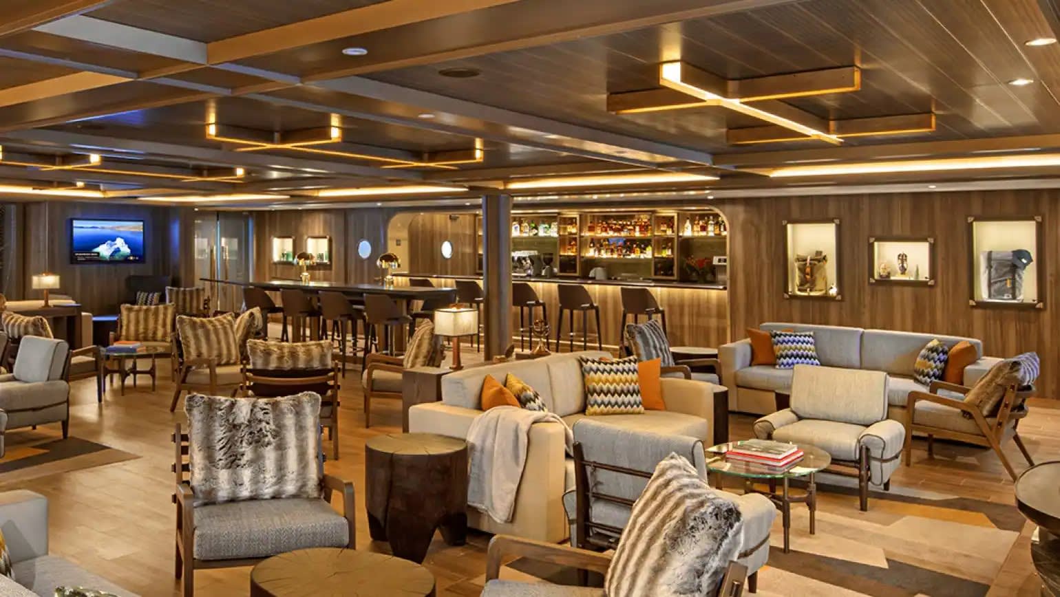 A sophisticated and elegantly designed expedition lounge aboard the Seabourn Venture, featuring