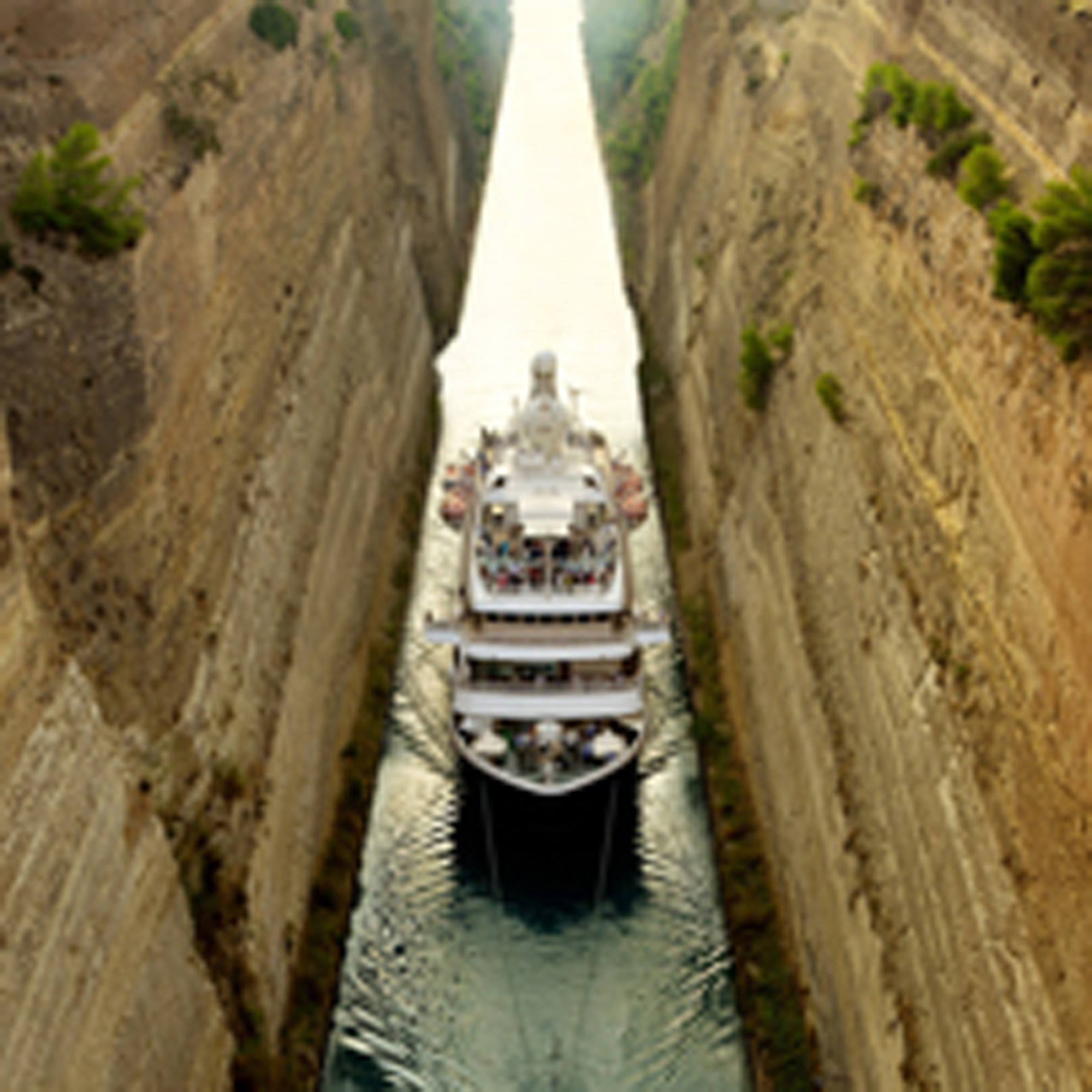 A large white cruise ship carefully navigates through an extremely narrow artificial waterway