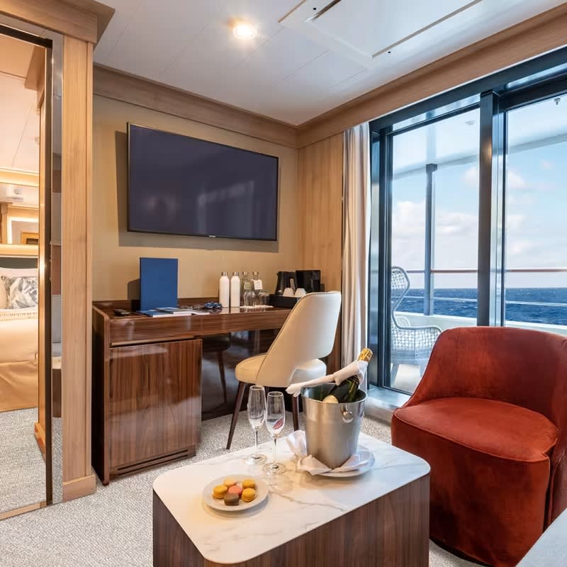 A luxurious superior suite aboard a Quark Expeditions vessel featuring floor-to-ceiling windows