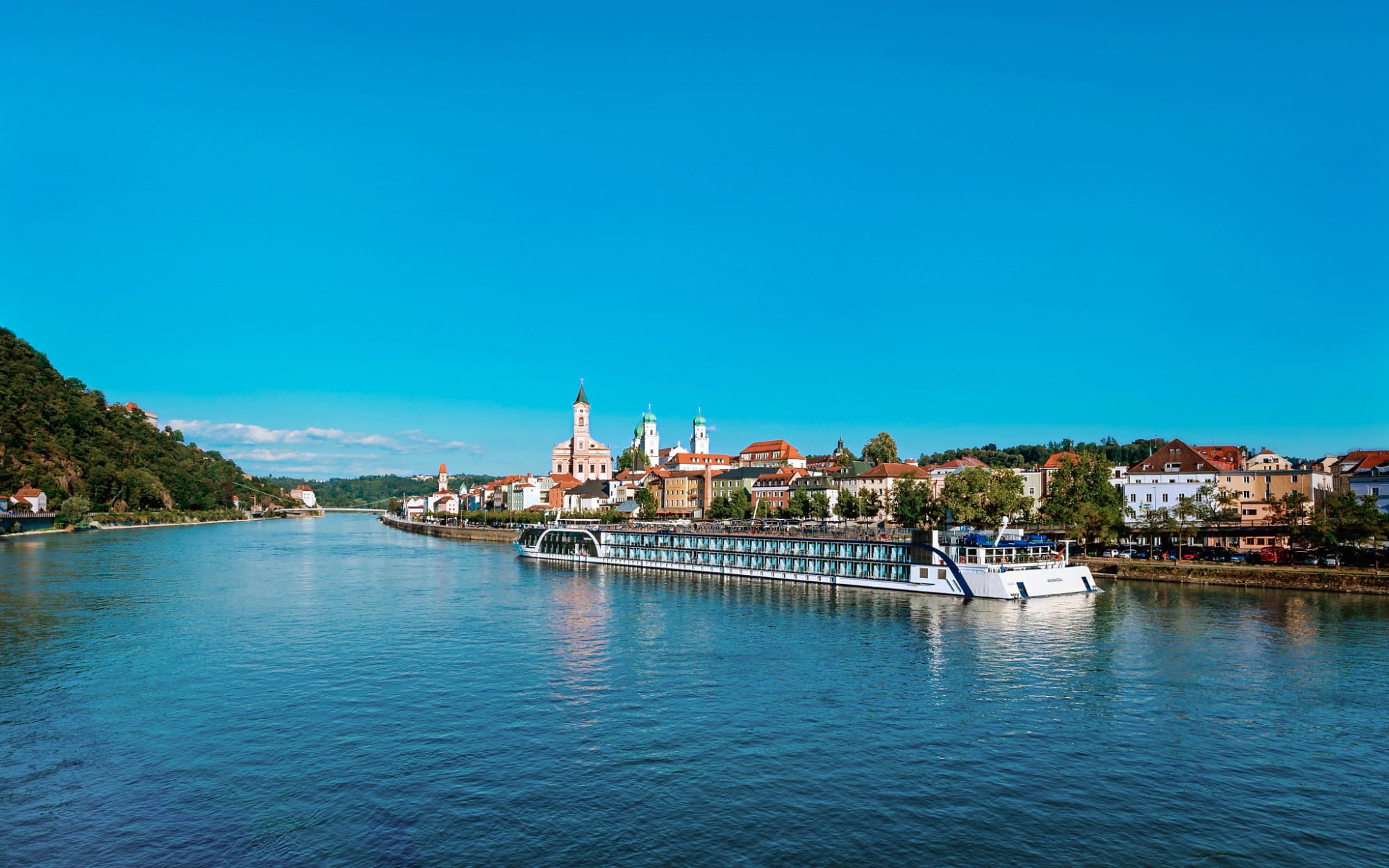 A modern river cruise ship operated by AmaWaterways navigates through the picturesque Danube River