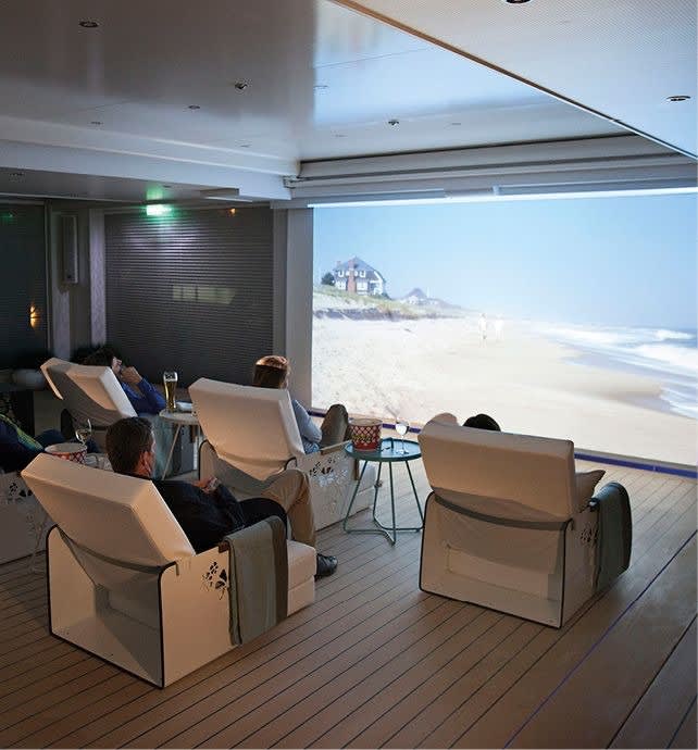 An elegant ship lounge or observation area featuring comfortable cream-colored armchairs arranged