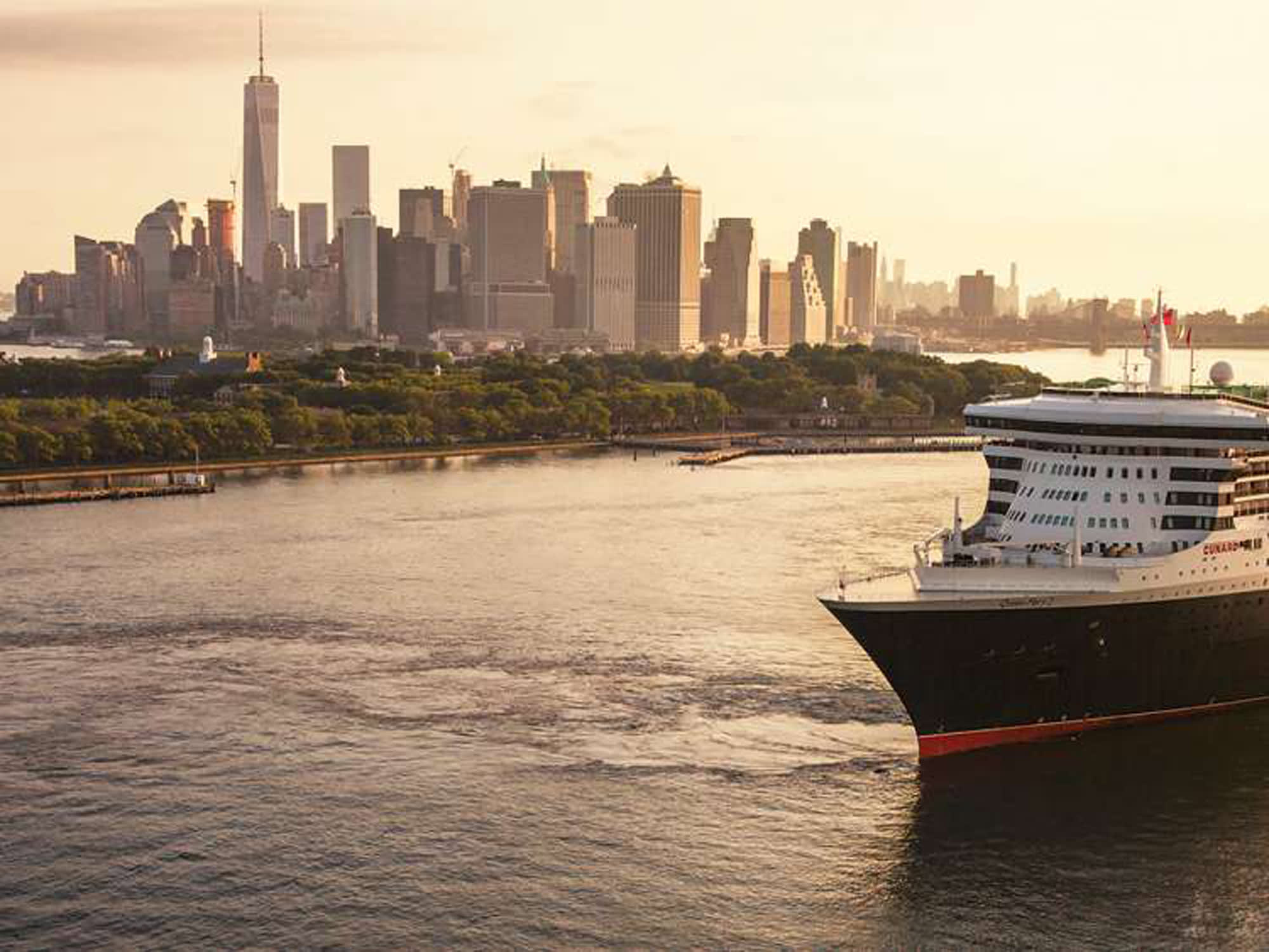 A large modern cruise ship with distinctive black and white hull design cuts through deep blue ocean waters, leaving a white wake behind. The vessel features multiple deck levels with contemporary architecture and appears to be a contemporary mega-ship cruising in open water.
