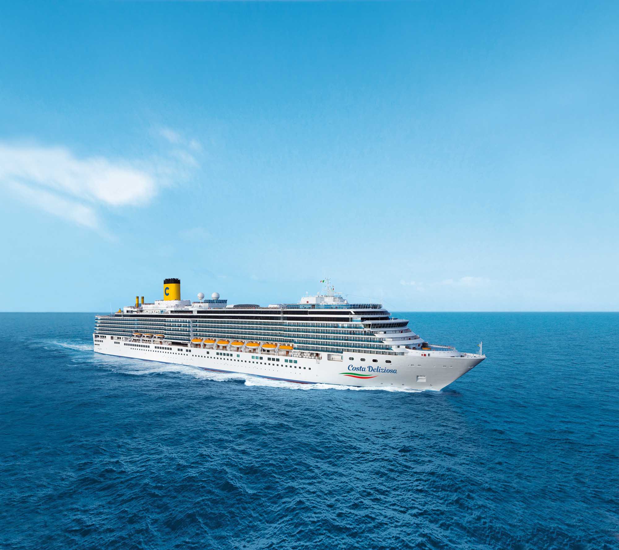 A large modern cruise ship, the Costa Delizosa, sails through clear blue ocean waters under