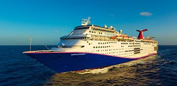 A large cruise ship operated by Carnival Cruise Lines sailing on open ocean waters under clear blue