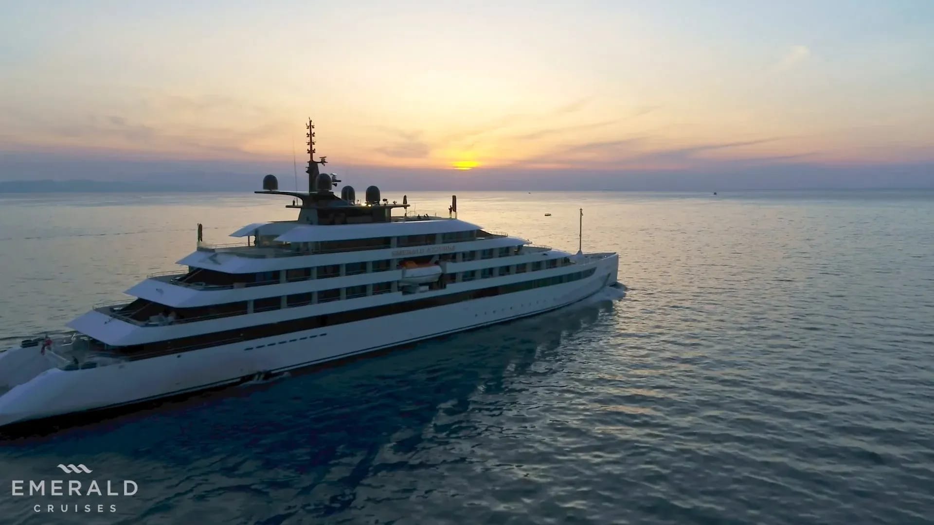 A magnificent luxury expedition yacht with multiple decks anchored in calm turquoise waters during