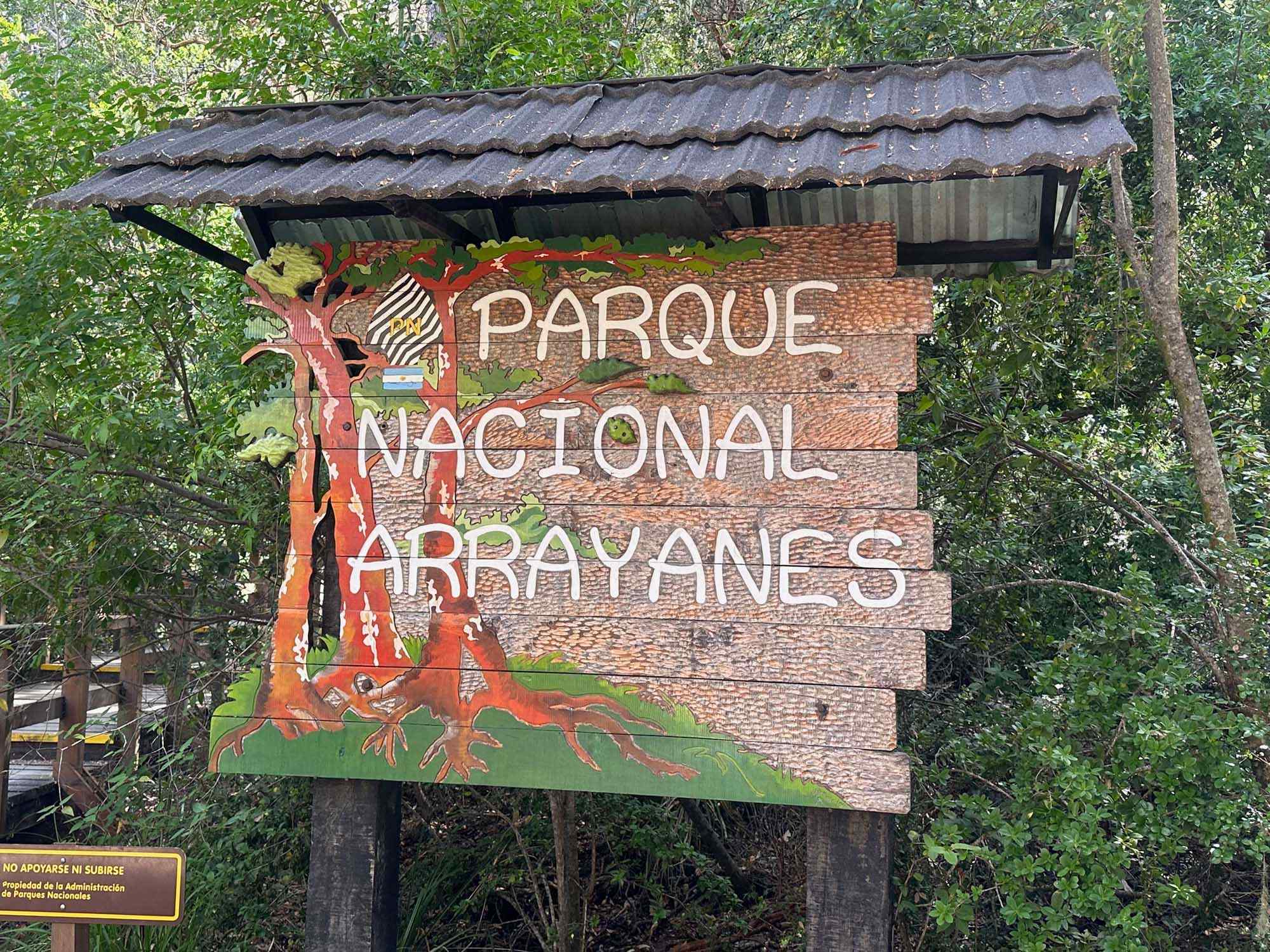 A rustic wooden entrance sign for Parque Nacional Arroyanes (Arrayanes National Park) surrounded