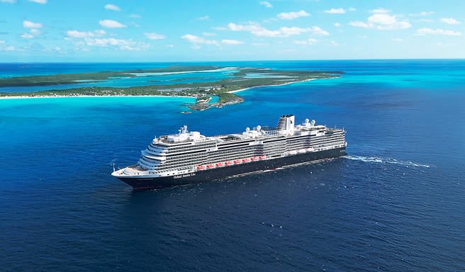 A large, modern cruise ship navigating through turquoise waters near a lush green island with