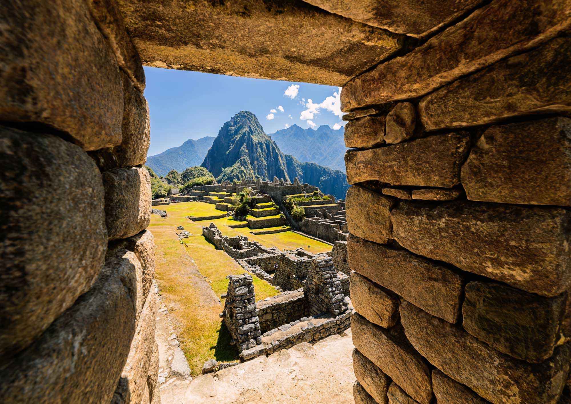 A breathtaking view of Machu Picchu's iconic mountain peak and terraced ruins framed through