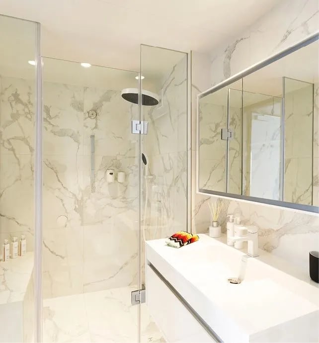 A contemporary, elegantly appointed bathroom featuring polished marble walls with subtle gray