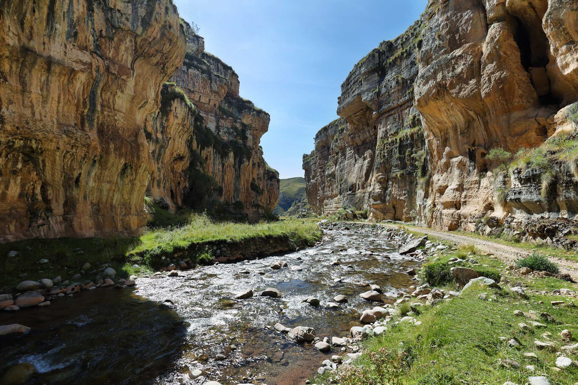 A dramatic limestone gorge carved by a flowing stream through the Reserva Paisajística Nor