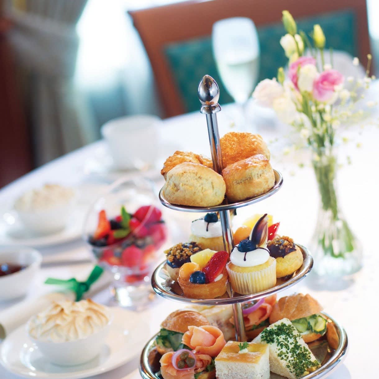 A luxurious tiered afternoon tea presentation featuring pastries, scones, finger sandwiches