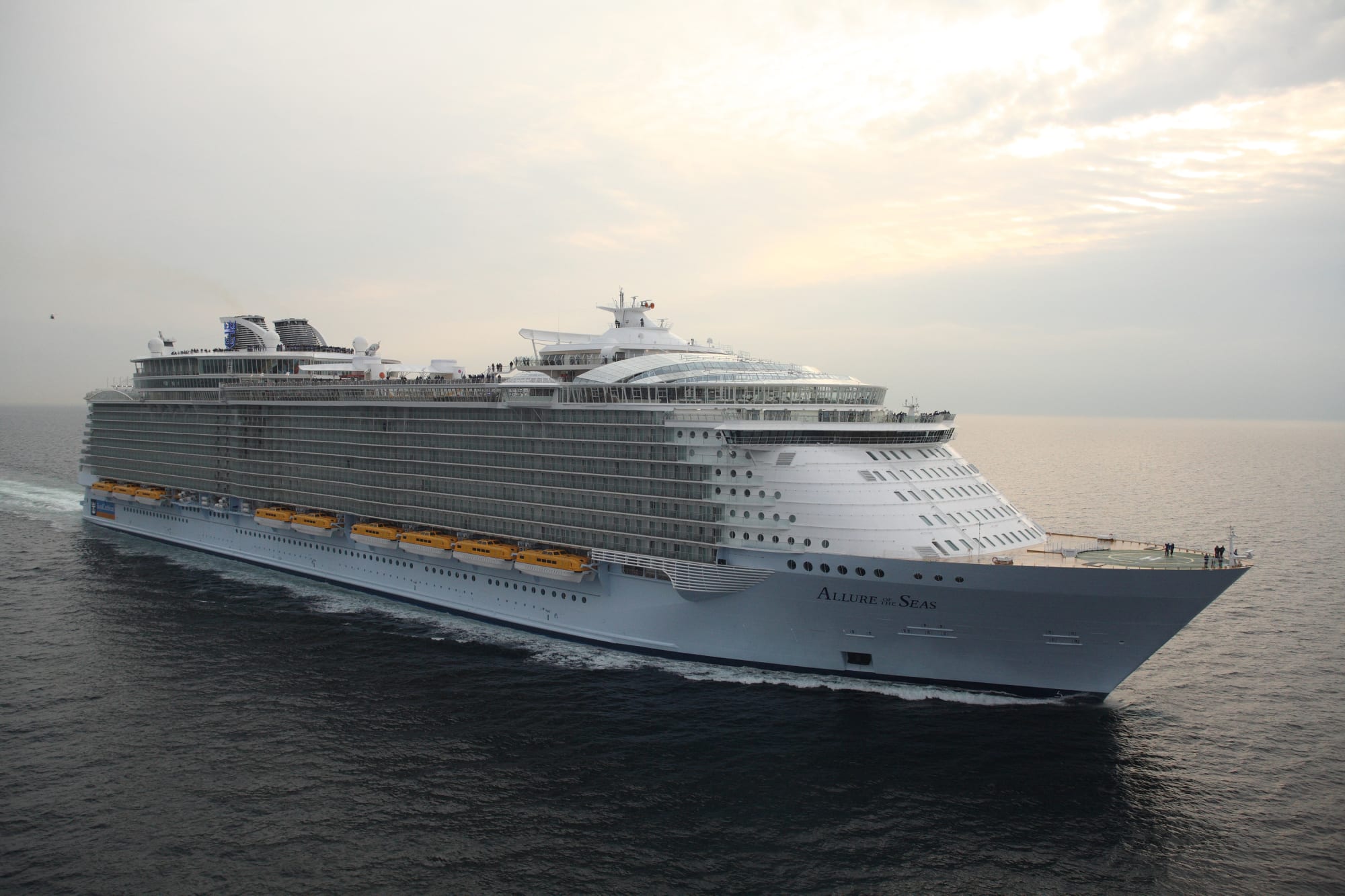 A massive Royal Caribbean cruise ship sailing on open waters during a soft, overcast day