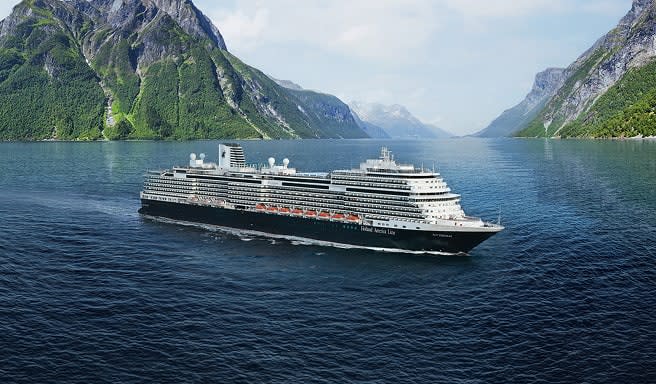 A large modern cruise ship sailing through a dramatic fjord with steep, green mountain slopes