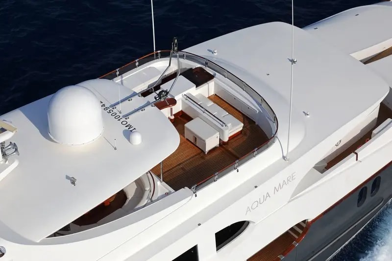 An aerial view of the Aqua Mare, a luxury motor yacht featuring an elegant sun deck with white