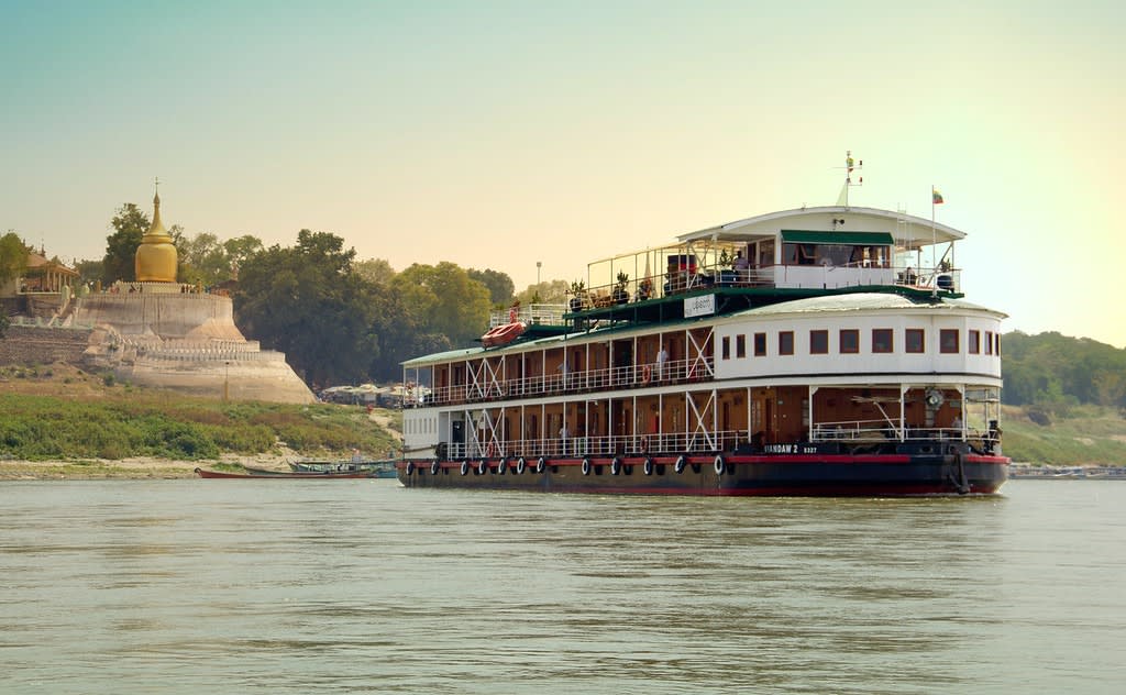 A traditional-style river cruise ship operated by Pandaw Cruises navigates the Irrawaddy River