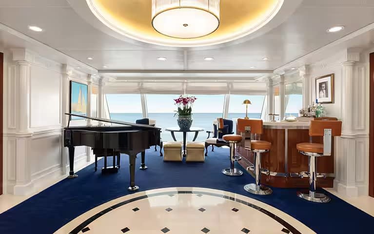 A luxurious owner suite aboard an Oceania Cruises O-Class ship, featuring a grand piano, elegant