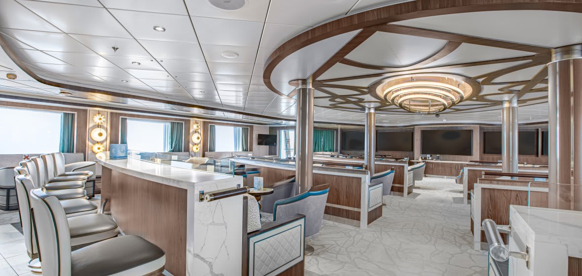 An elegant and spacious lecture room or lounge aboard a luxury cruise ship, featuring curved wood