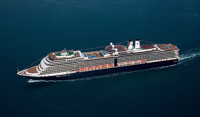 A large, contemporary cruise ship sailing smoothly across deep blue waters, showcasing multiple