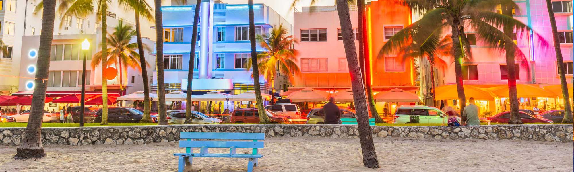 A vibrant evening scene of Miami's iconic Art Deco Historic District featuring pastel-colored