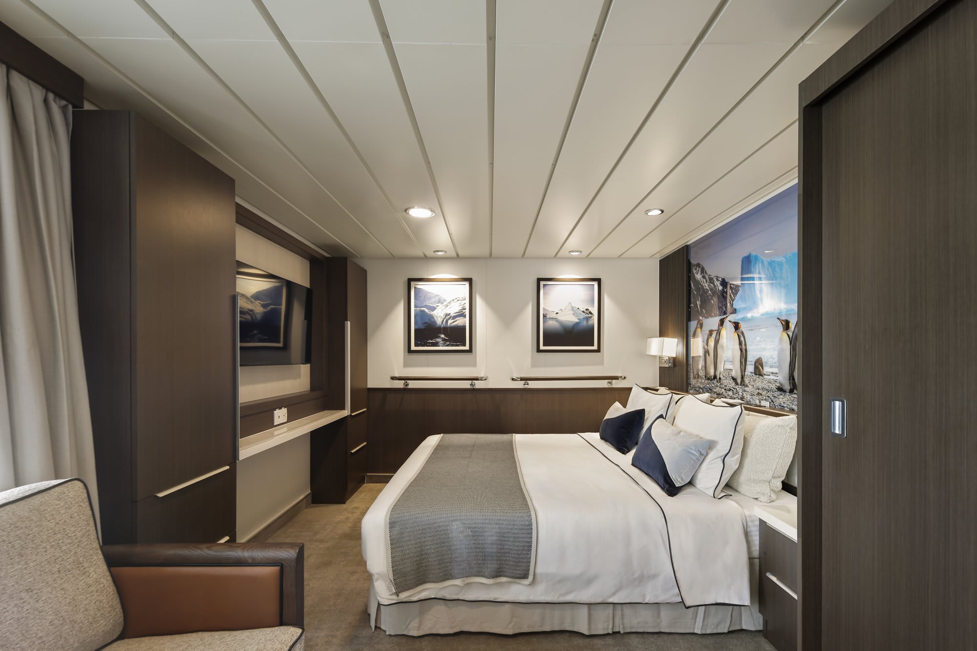 An elegantly designed cruise ship cabin featuring modern minimalist decor with recessed lighting