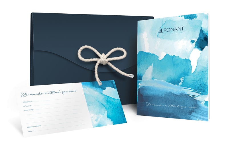 An elegant luxury gift package from Ponant cruise line featuring a dark navy envelope with natural