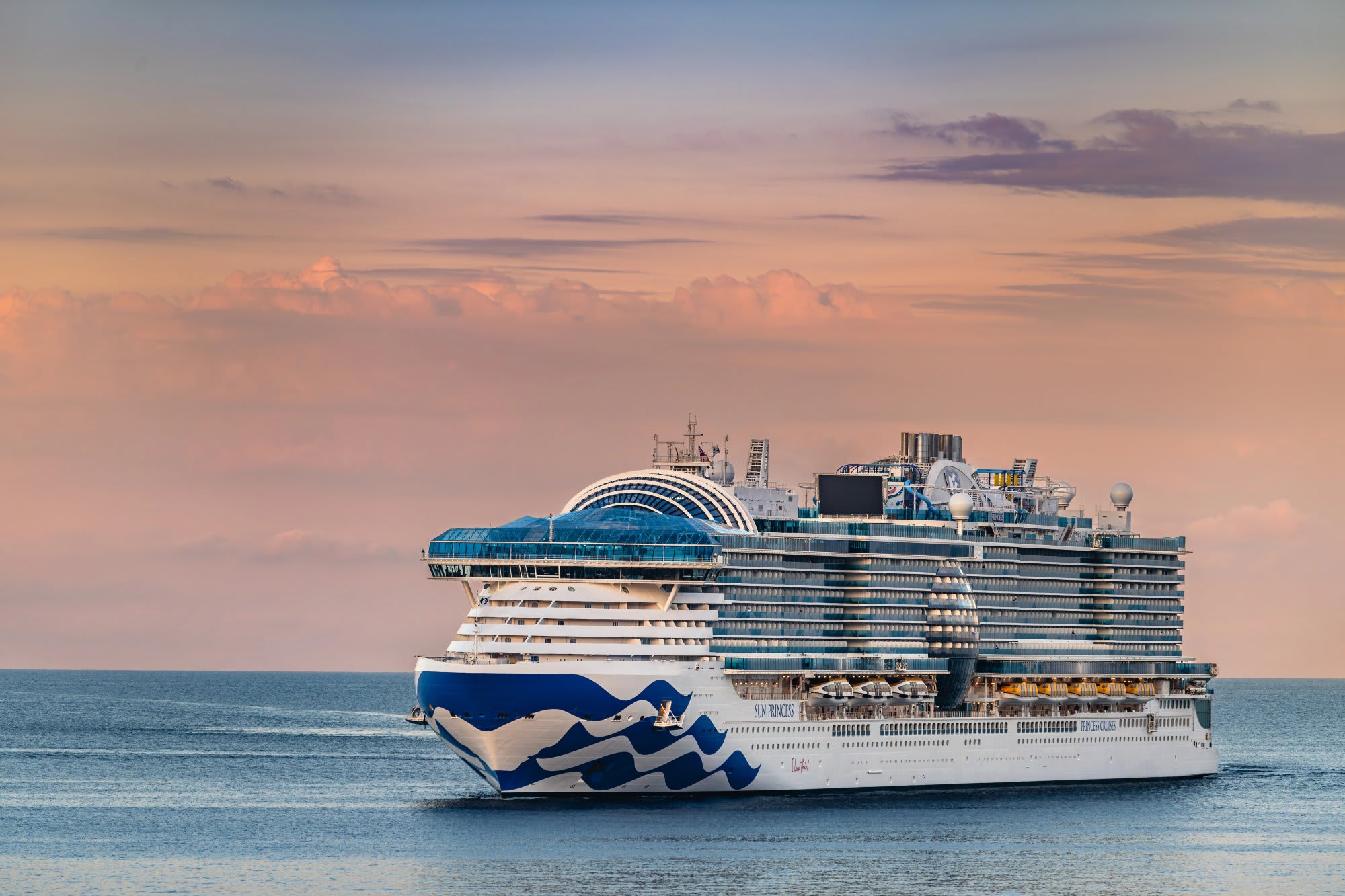 A large modern cruise ship featuring Princess Cruises' distinctive blue and white hull design sails