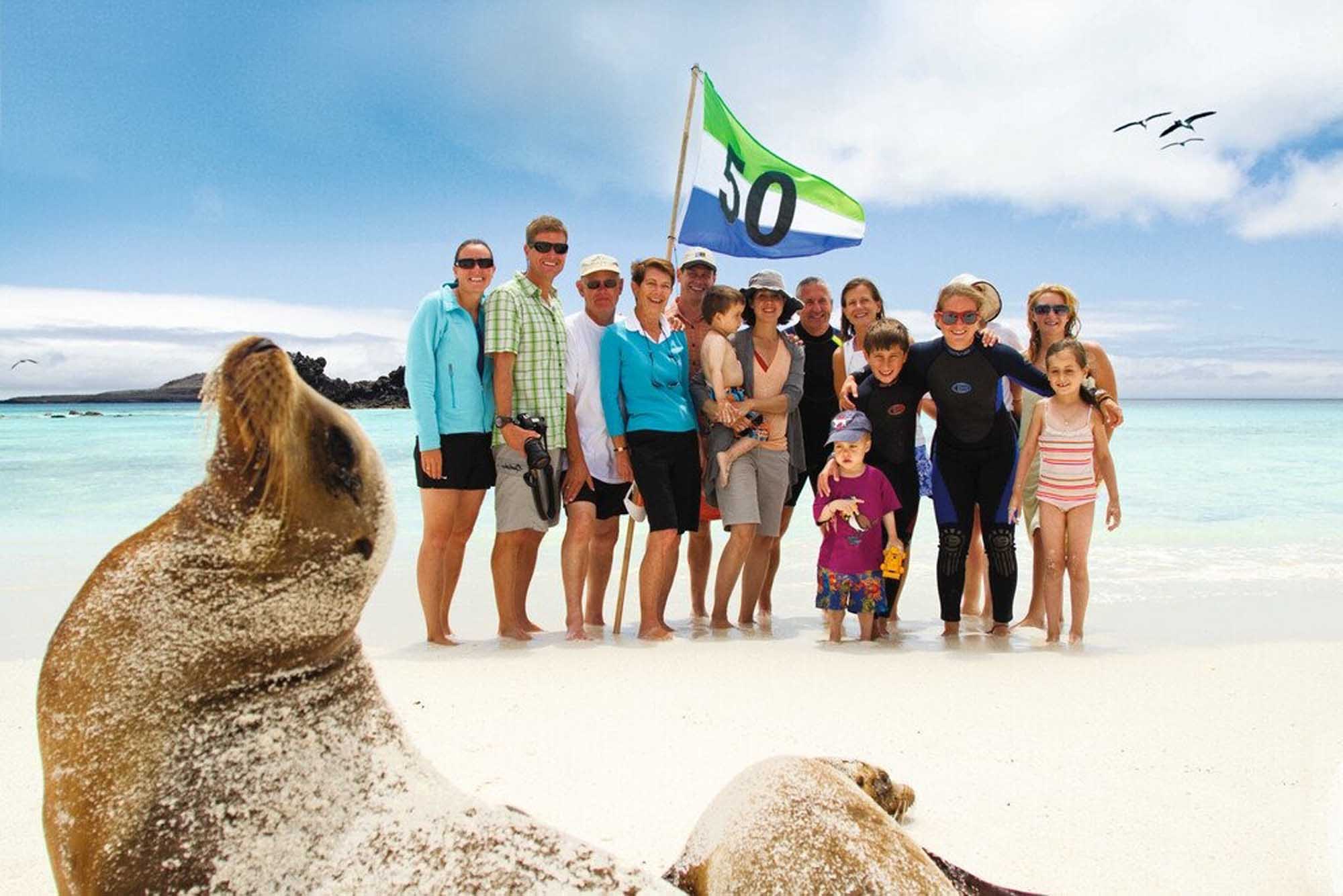 A group of passengers and crew from a Lindblad Expeditions-National Geographic expedition pose on