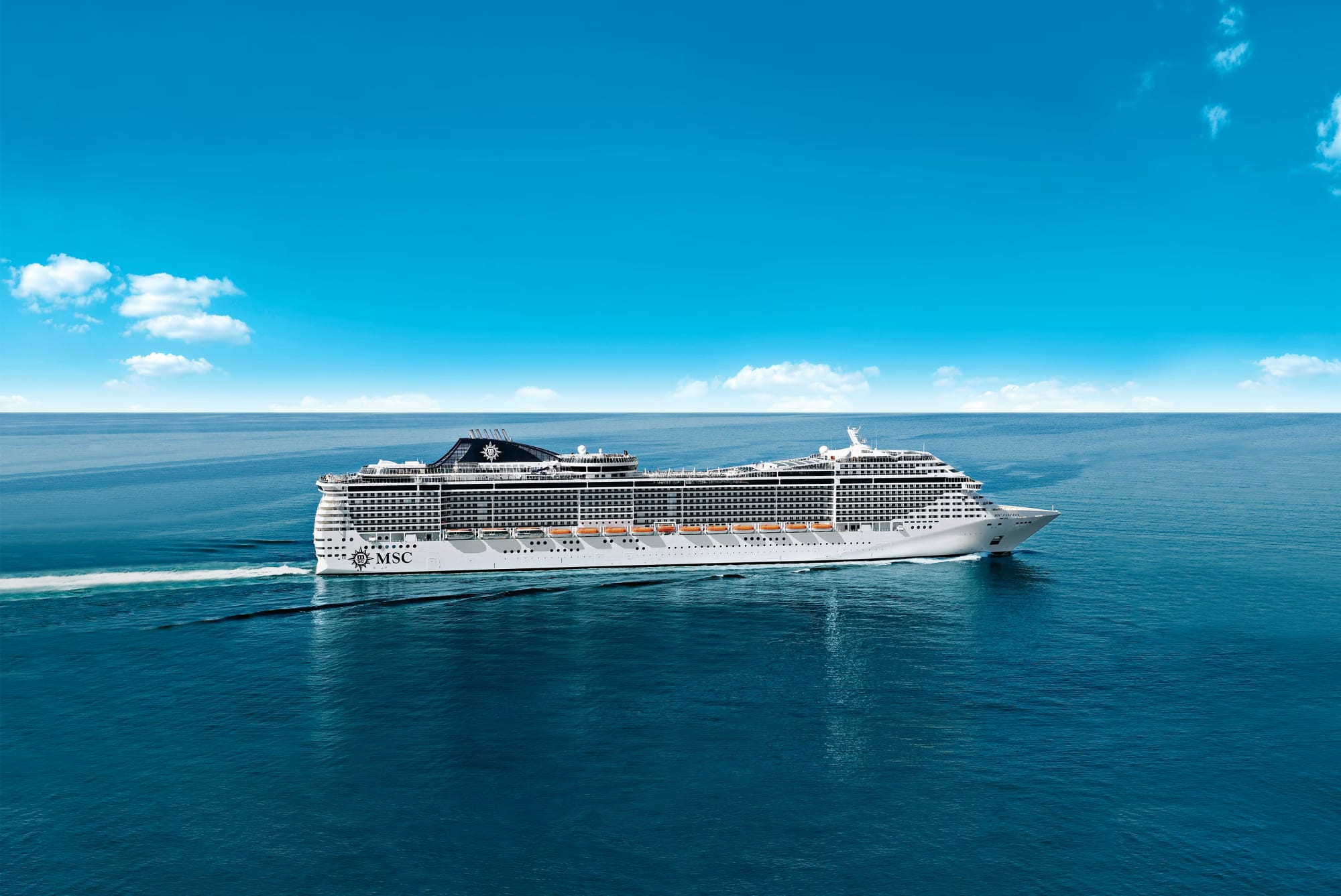 A large modern cruise ship operated by MSC Cruises sailing on calm turquoise ocean waters under