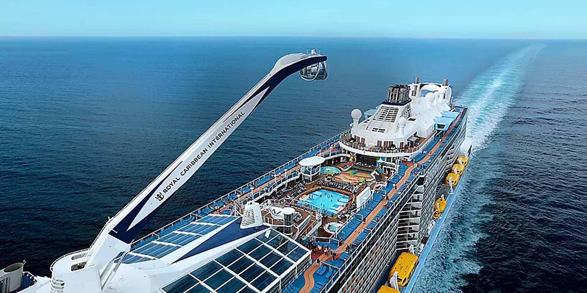 An aerial photograph of a large modern cruise ship at sea, showcasing its distinctive features