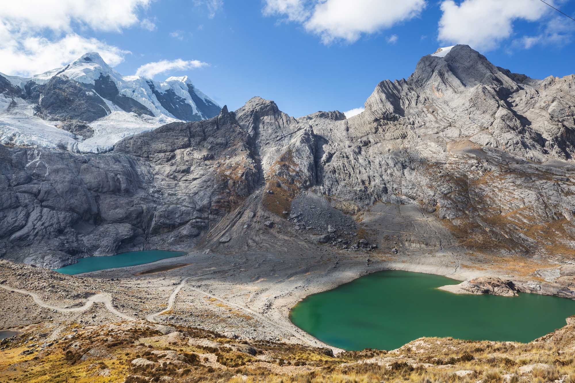 A stunning high-altitude landscape in Peru's Cordillera Blanca mountain range, featuring emerald