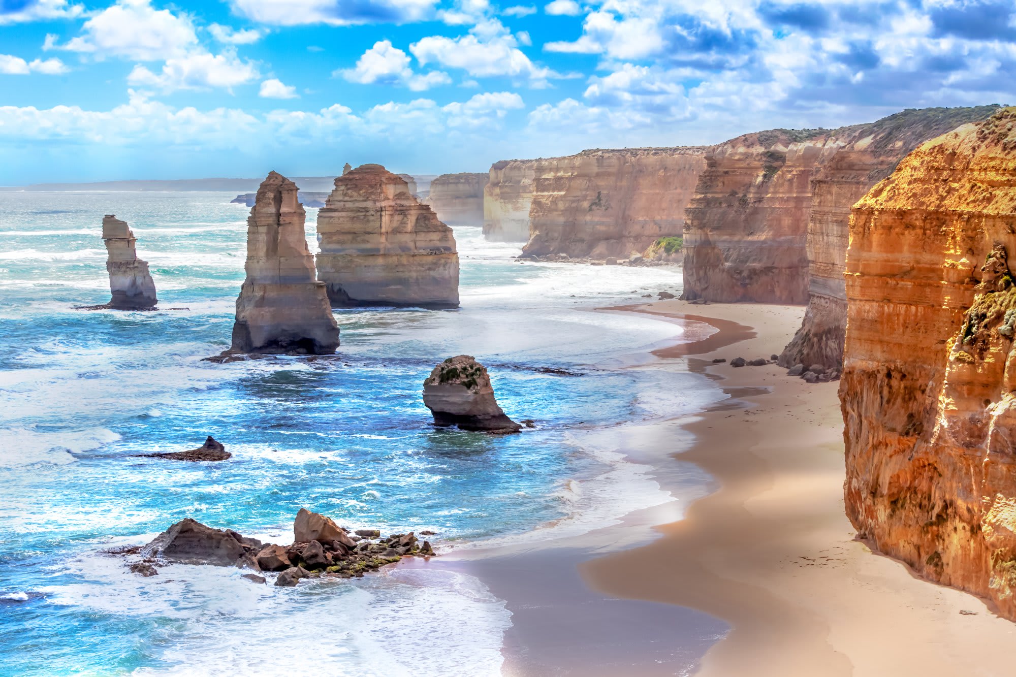 A stunning coastal landscape featuring the iconic Twelve Apostles rock formations rising