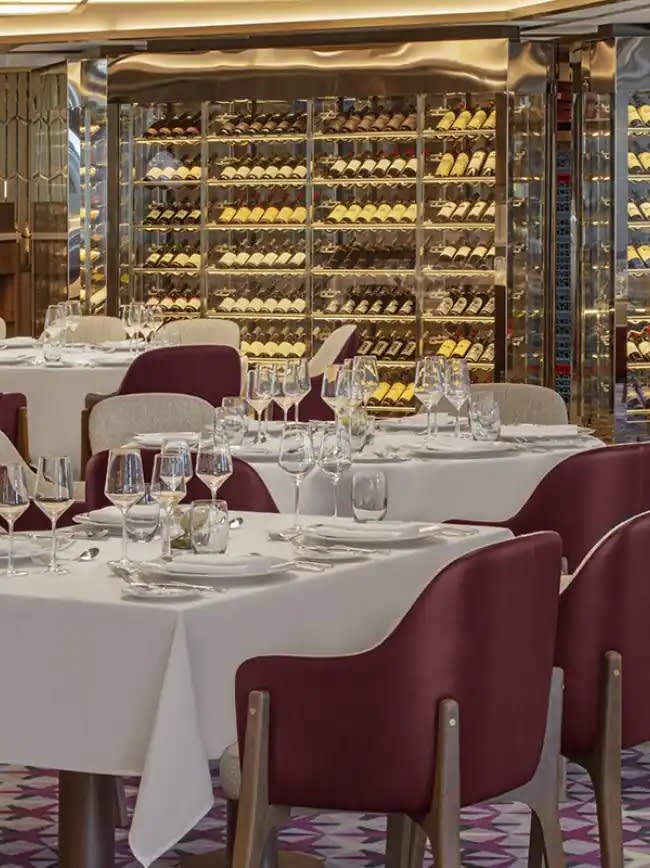 An elegant fine dining restaurant aboard the Seabourn Venture, featuring formally set tables
