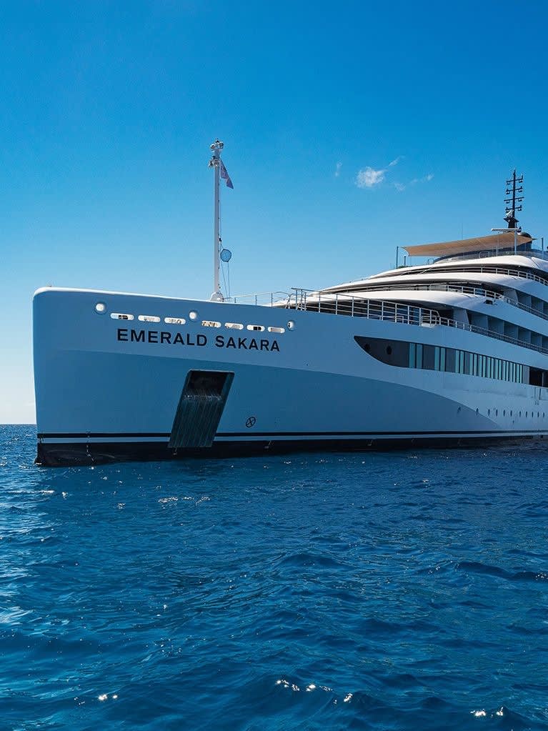 A stunning view of the Emerald Sakara, a modern luxury expedition yacht, anchored in crystal-clear