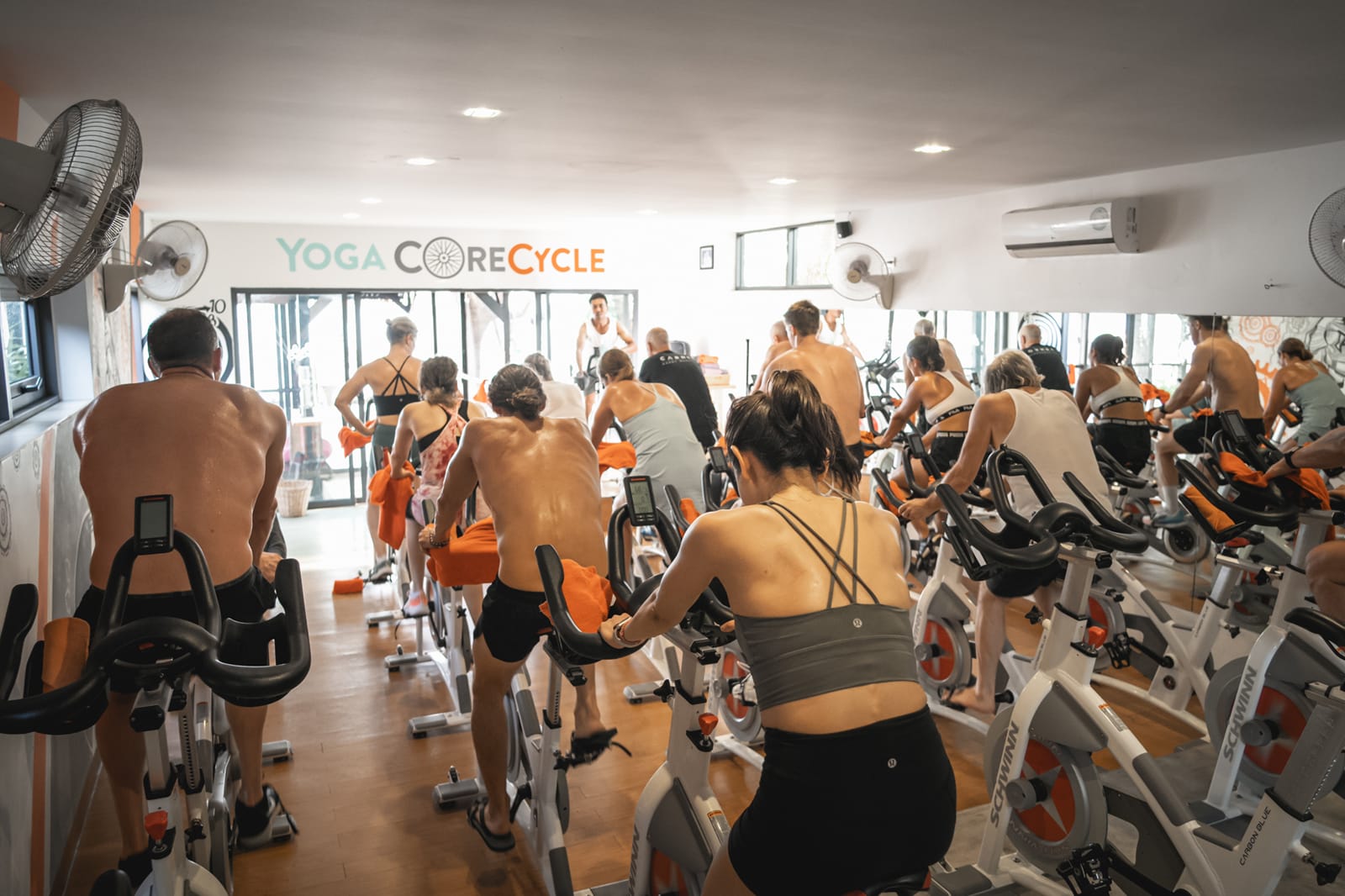 Group fitness class at Yoga Core Cycle studio with participants on stationary bikes