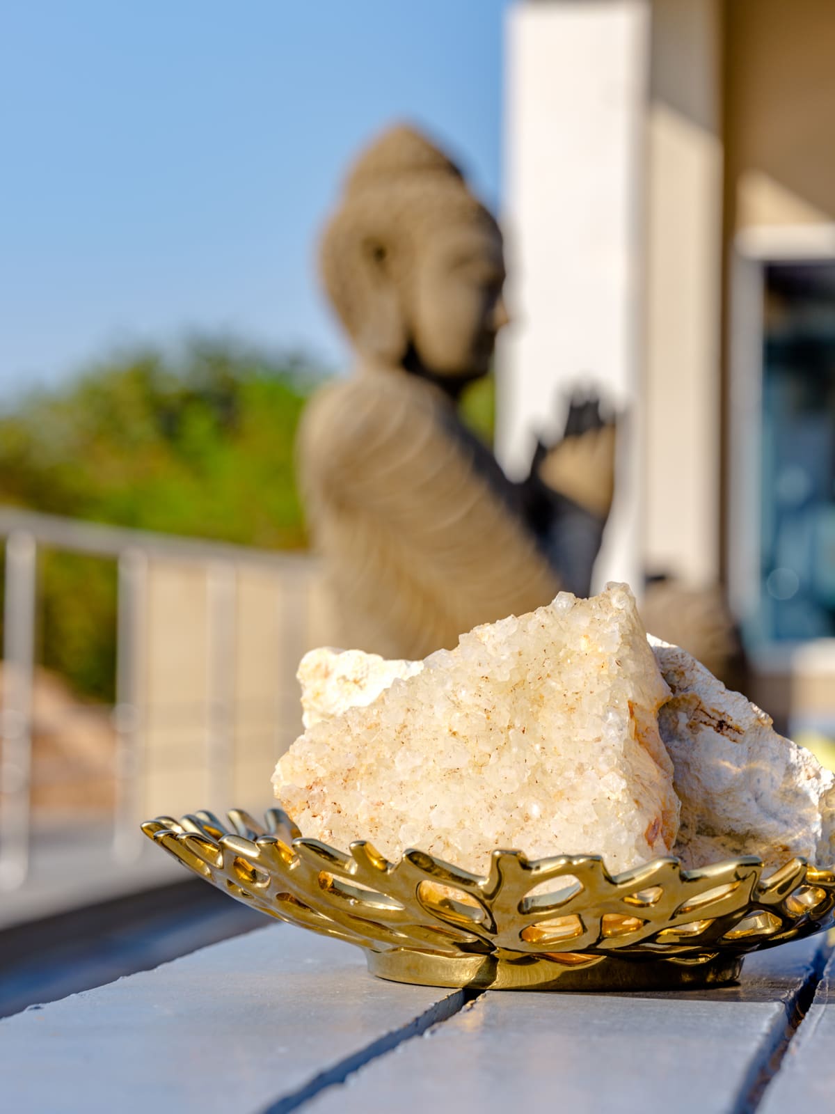 Rough stone rock in decorative gold leaf dish with blurred statue in background