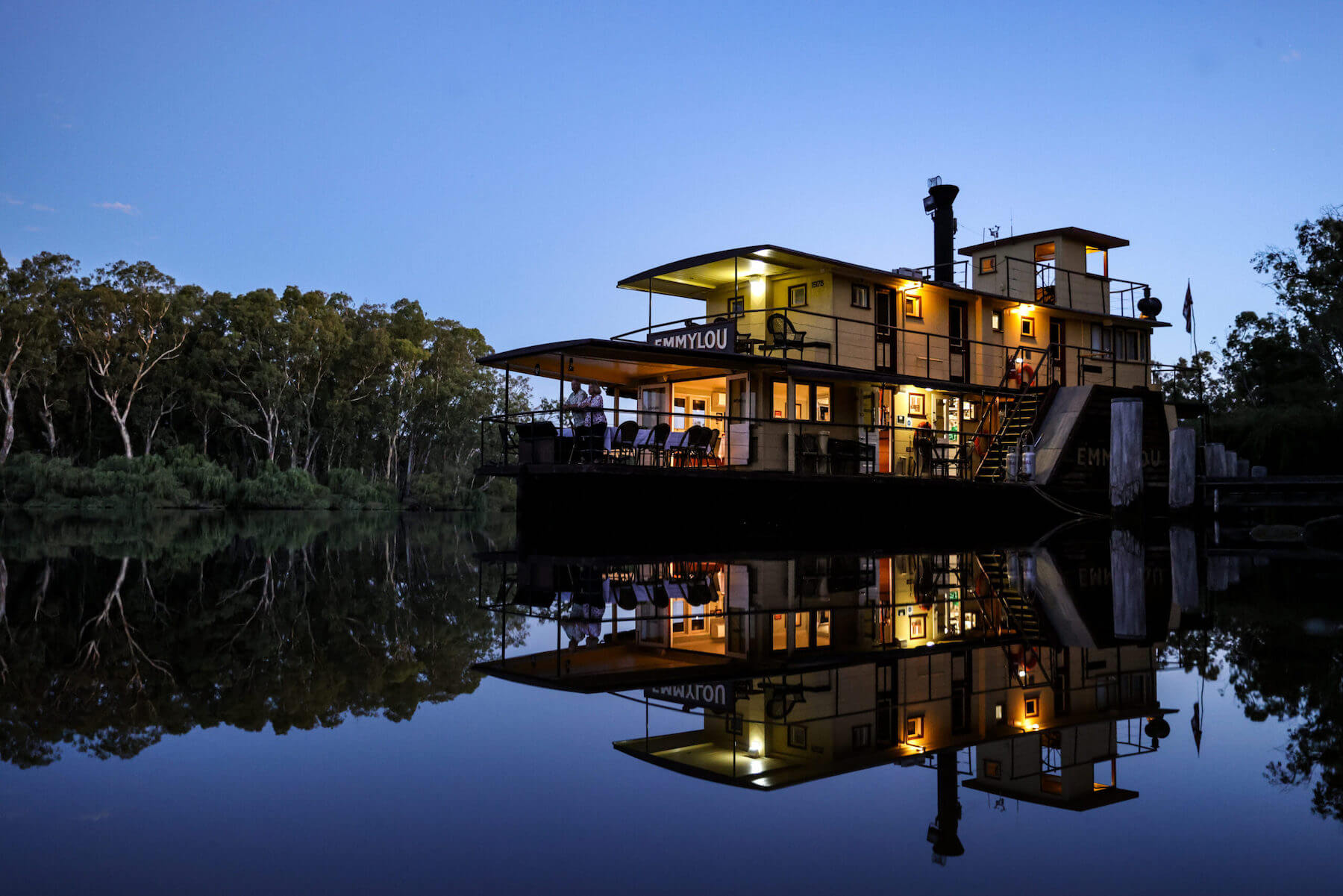 A striking nighttime image of the PS Emmylou, a heritage riverboat, beautifully lit against