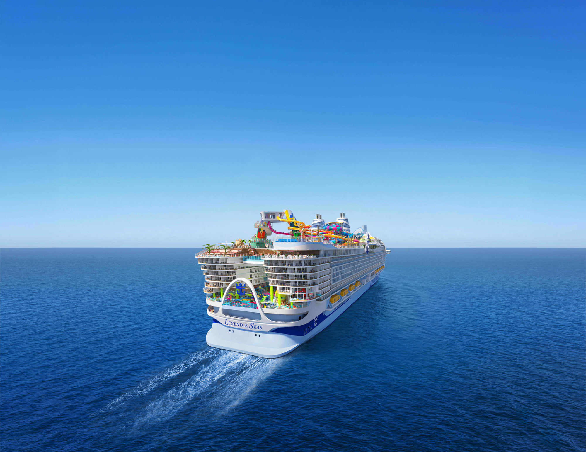 A large modern cruise ship photographed from an aerial perspective sailing through calm blue ocean