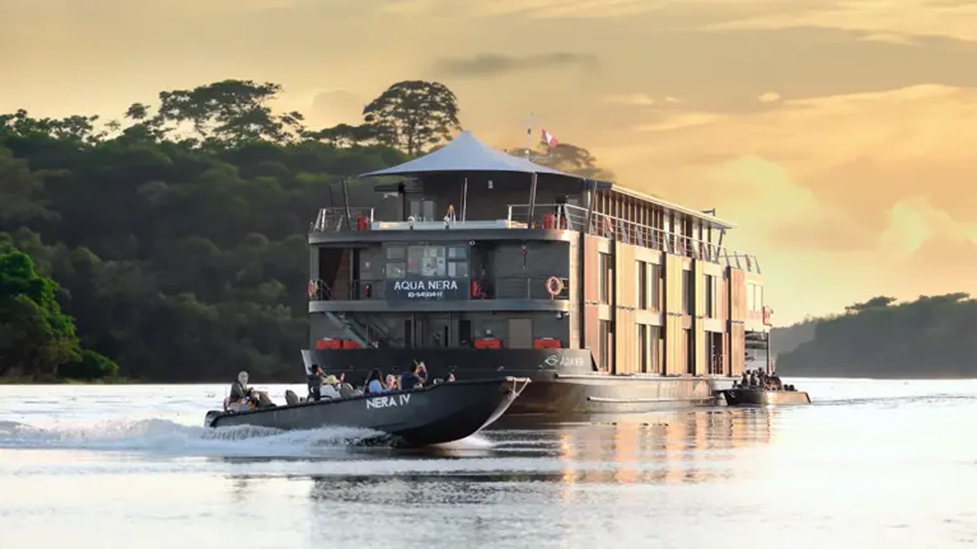 A luxury river cruise ship named Aqua Nera navigating through a lush Amazon rainforest landscape
