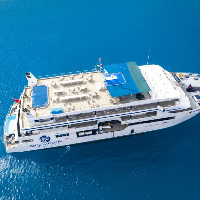 An overhead aerial photograph of the Blue Lagoon cruise ship anchored in crystal-clear turquoise