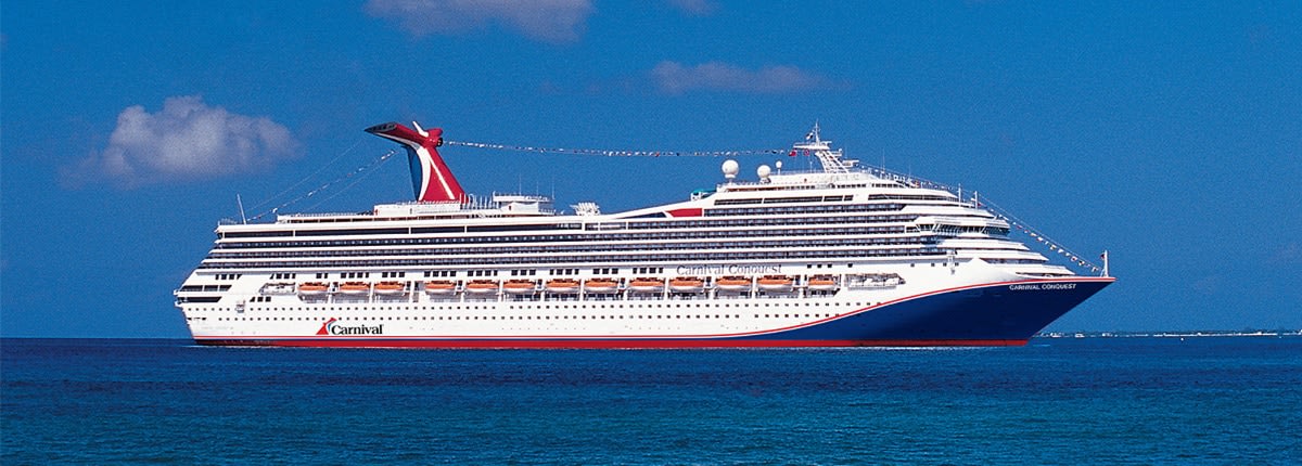 Carnival Cruise Ship at Sea A large Carnival cruise ship sailing on deep blue waters under a clear sky with scattered clouds